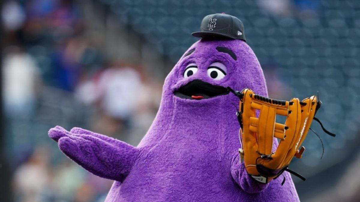 An image of Grimace, the large purple McDonald's mascot, with a baseball glove and hat.